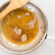 Browned butter in a frying pan with a wooden spoon